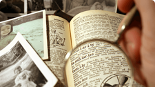 Old photos and a dictionary seen through a magnifying glass.